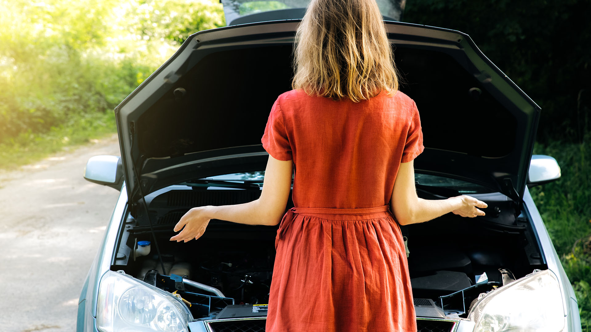 Motorschaden am Auto – Frau prüft liegengebliebenes Fahrzeug